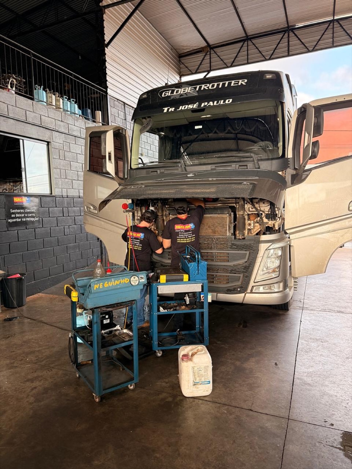 Volvo FH com cabine basculada e mecânicos da Agro AR trabalhando